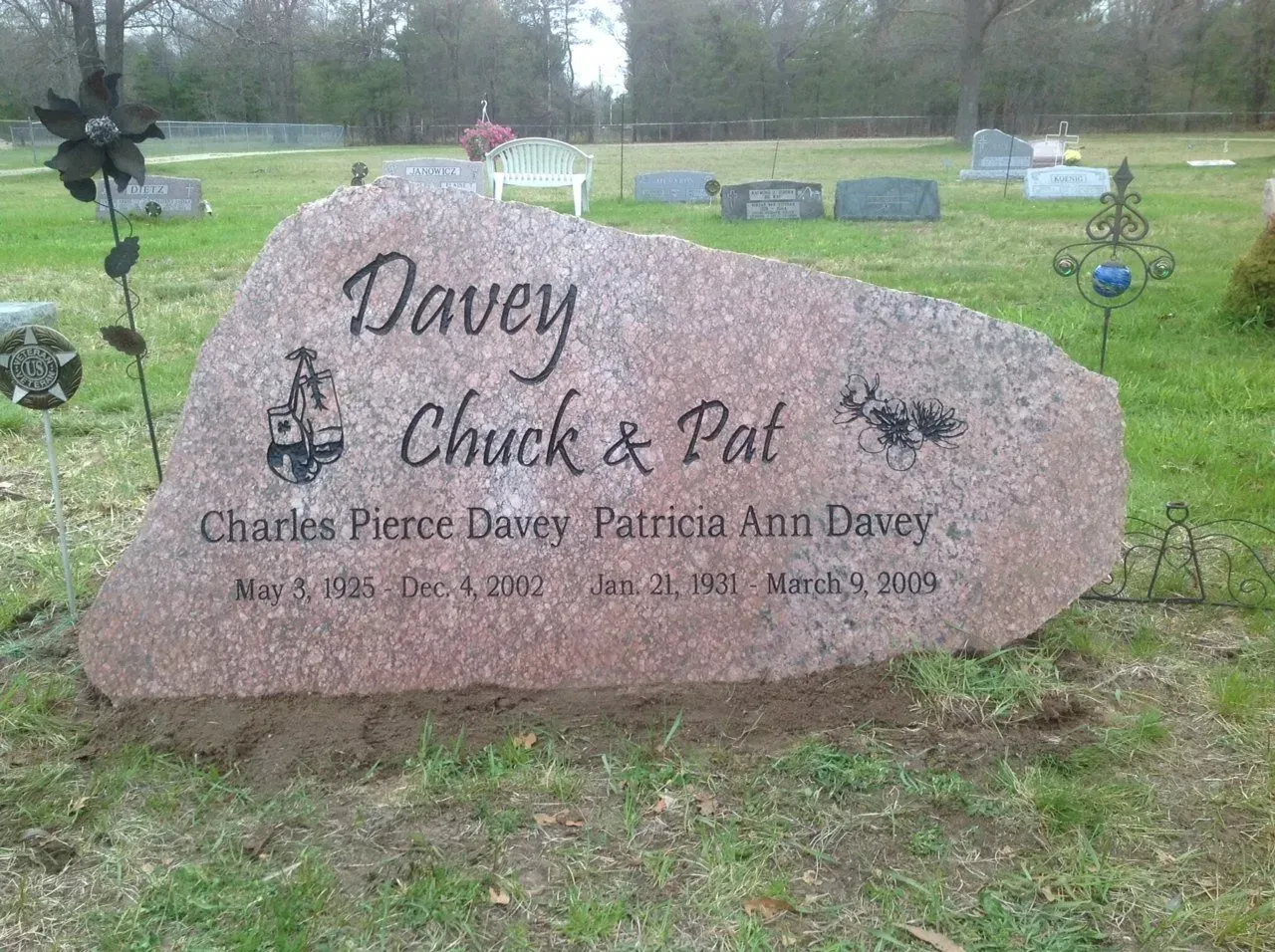 Pink granite tombstone in a cemetery with names Davey, Chuck & Pat, and dates.