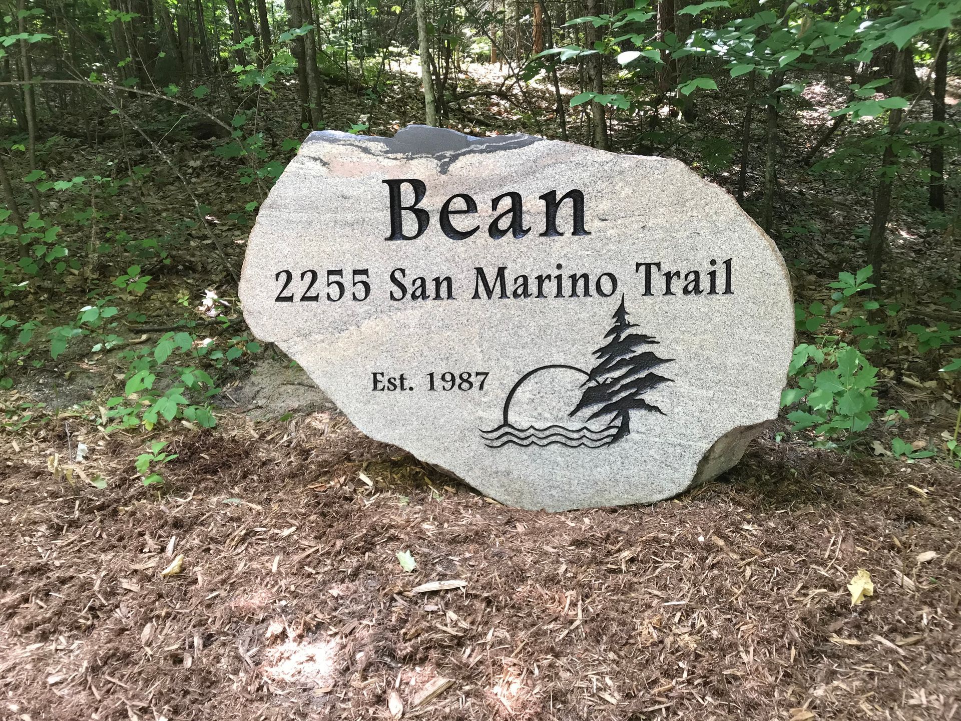Granite stone marker for Bean residence at 2255 San Marino Trail, established 1987, with tree and water symbol.