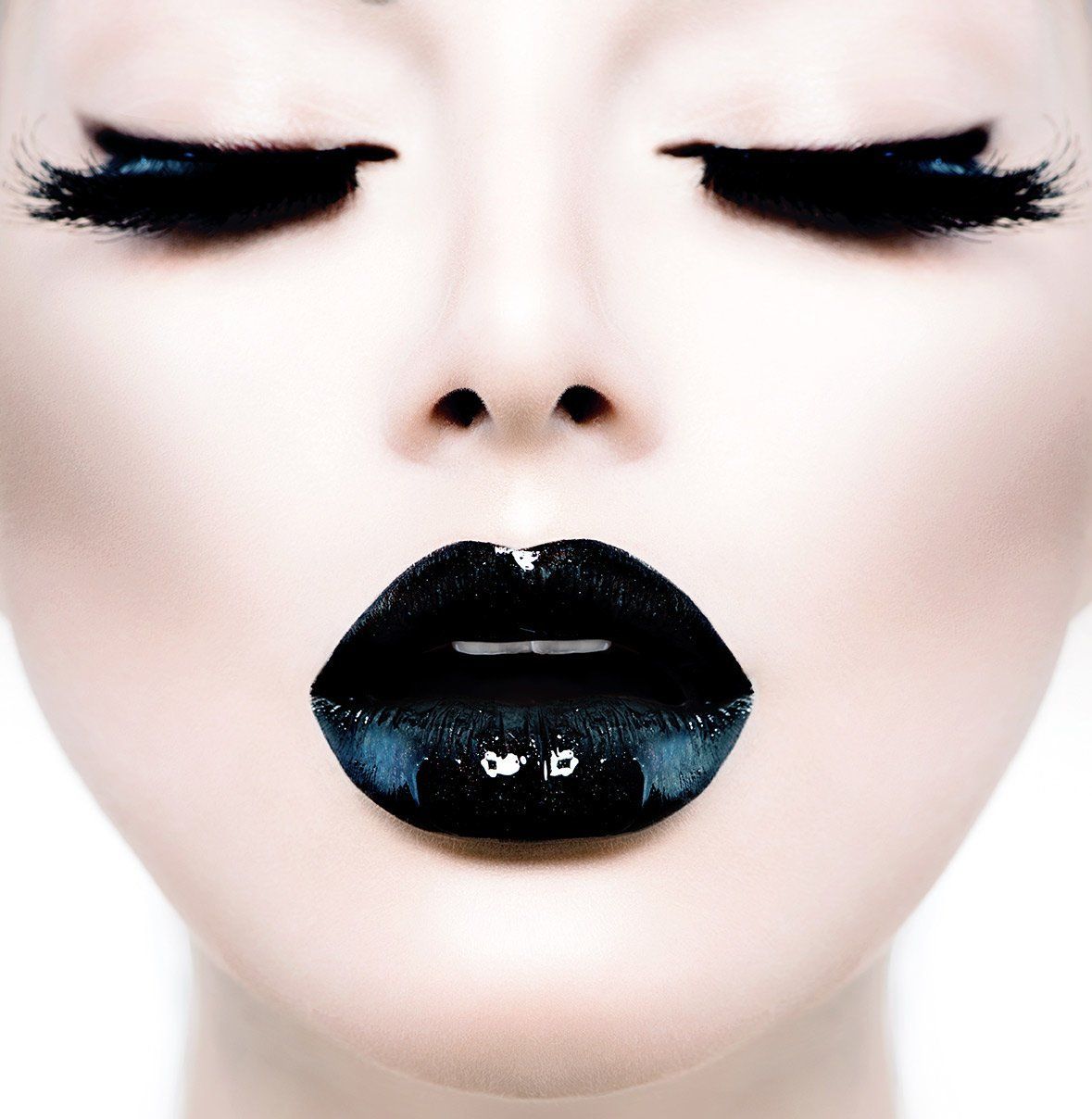 Woman with closed eyes, black lipstick, and dramatic eye makeup.