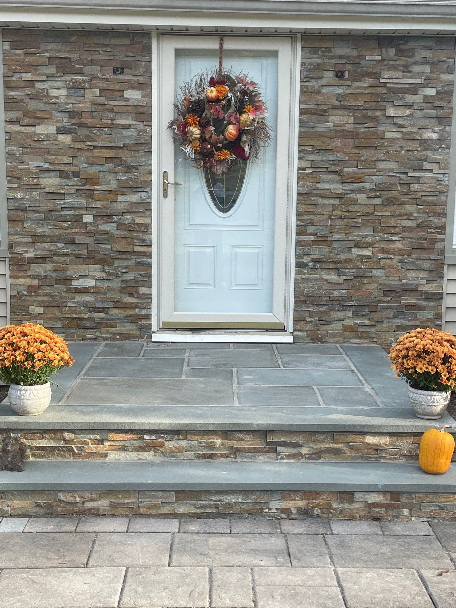 A newly repaired concrete steps leading to a front door with a wreath on it