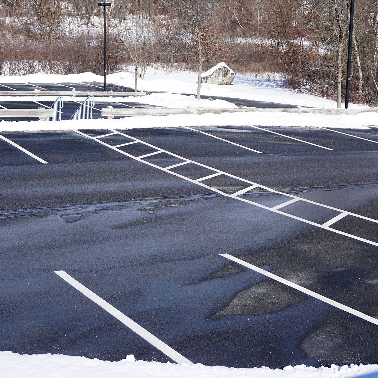 An empty parking lot with snow on the ground.