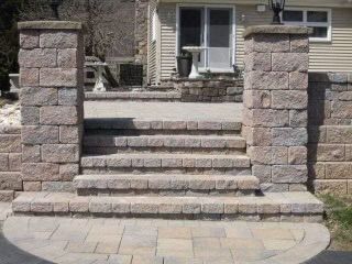 A stone wall with steps leading to a house