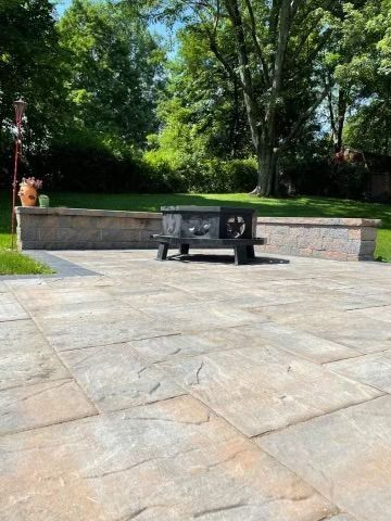A cozy patio with a fire pit and a bench