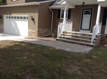 A cozy home with a driveway and steps leading to the front door.