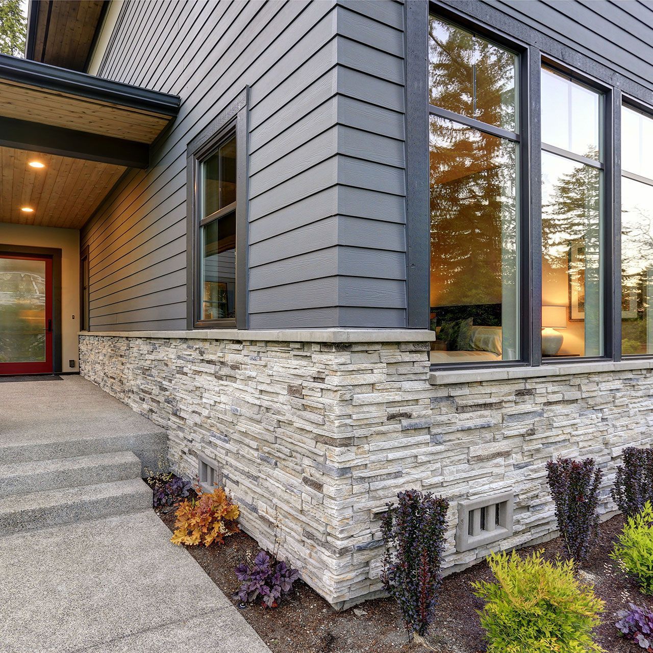Stone veneer siding and concrete pathway.