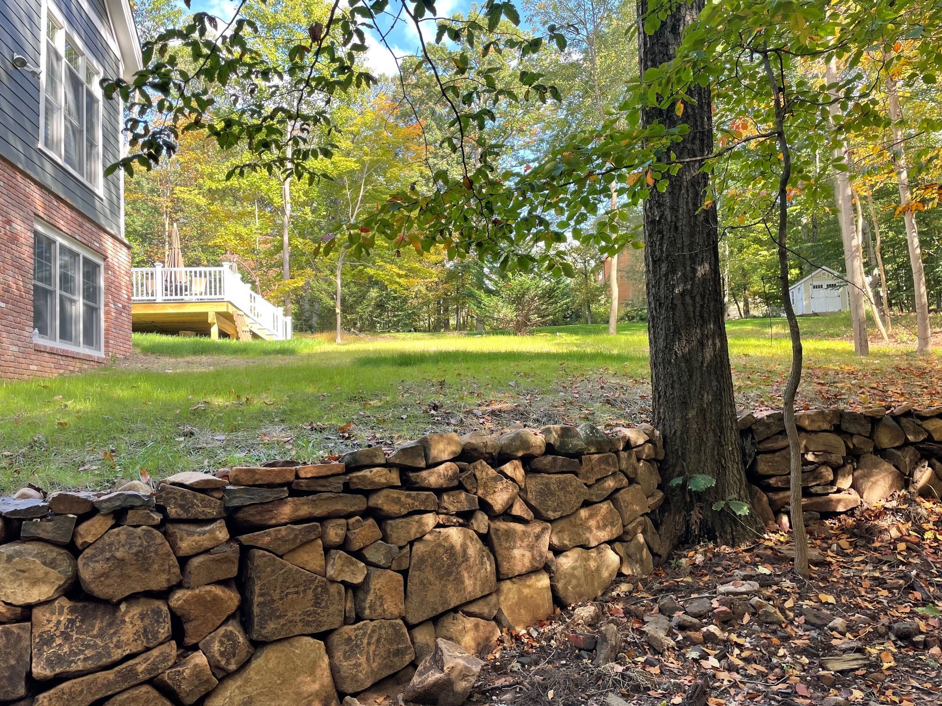 A stone wall standing in a yard.