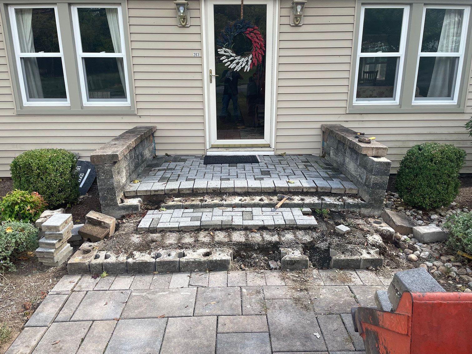 A brick patio is being built in front of a house