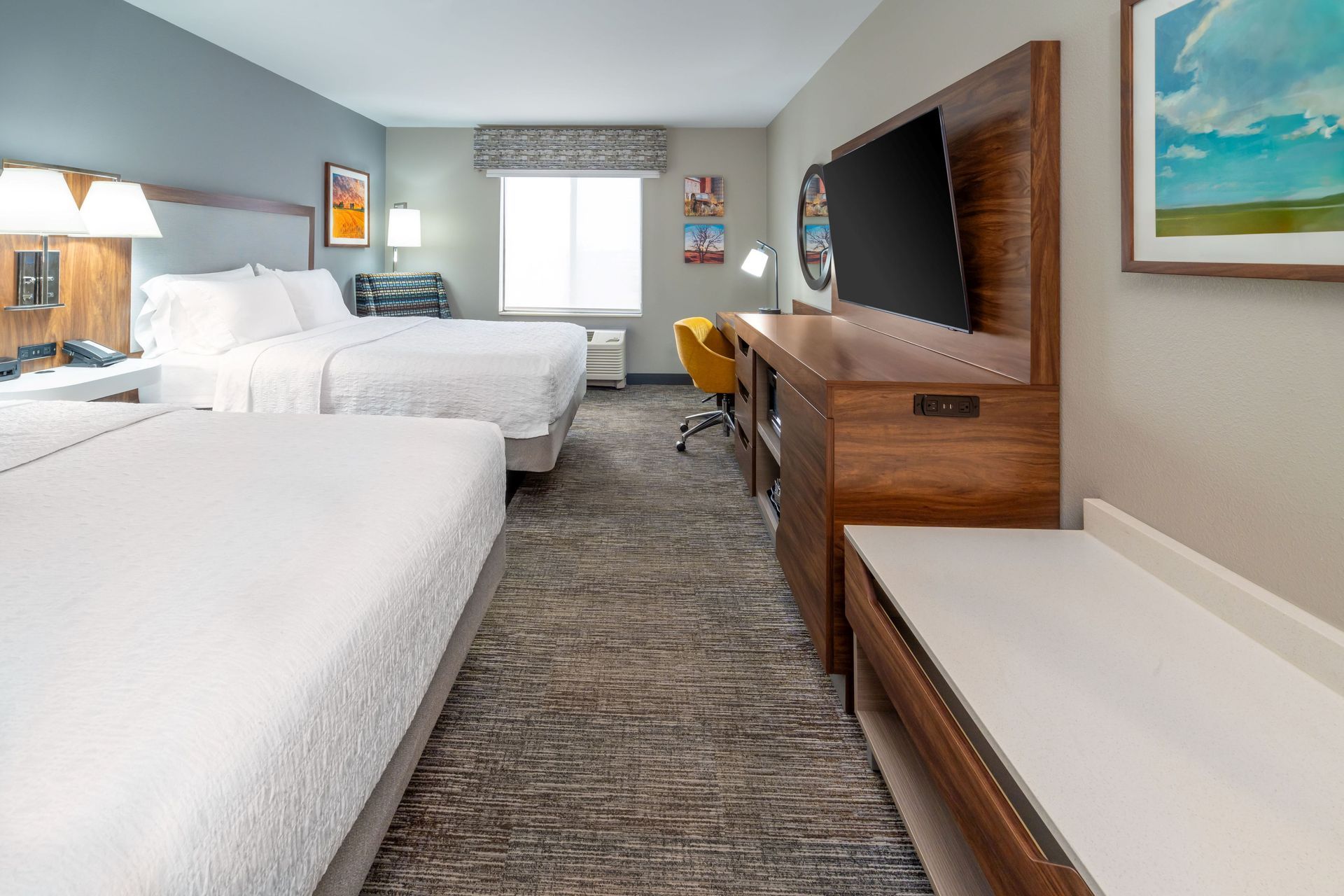 A hotel room with two beds and a flat screen tv.