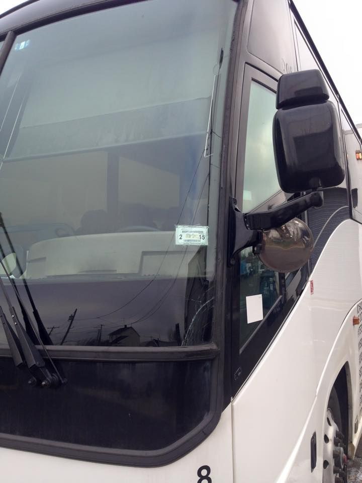 Front view of a silver and black coach bus parked outdoors
