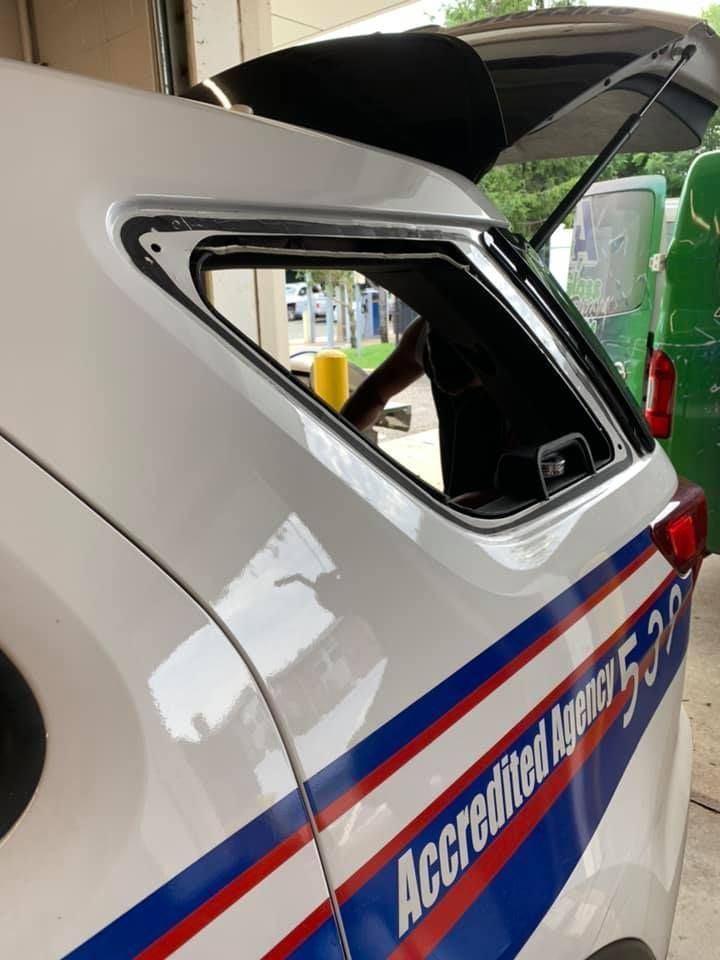 White emergency vehicle with open rear hatch, showing red and blue stripes and “Accident…” lettering