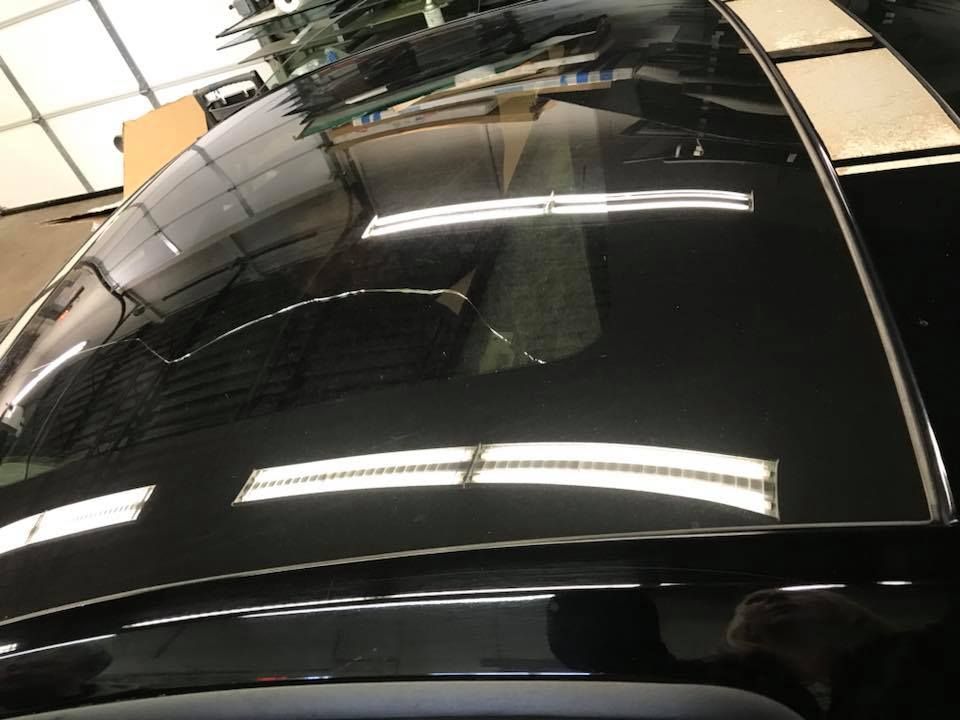 Black car roof with glossy reflections inside a garage