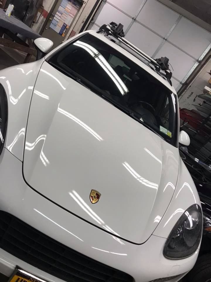 White Porsche sports car parked in a garage, angled front view