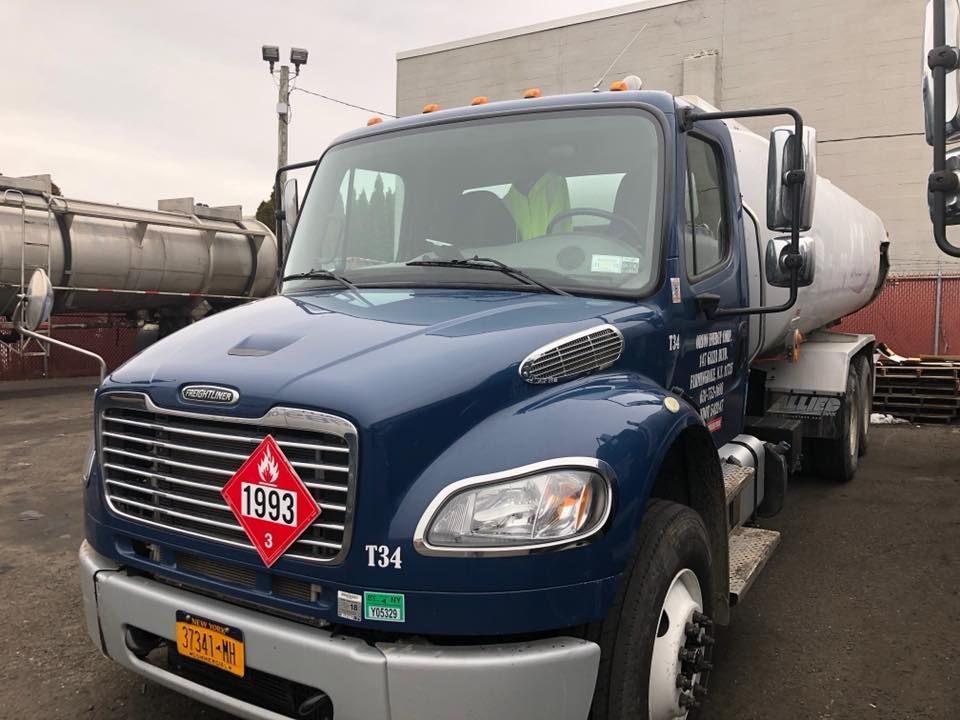 Blue tanker truck parked in a lot, front view with a red 1999 sign on the grille.