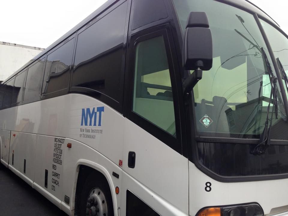 White and black coach bus parked at a curb, marked with MMT logo and number 8