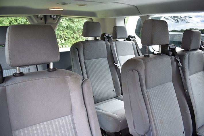 The inside of a van with gray seats and headrests