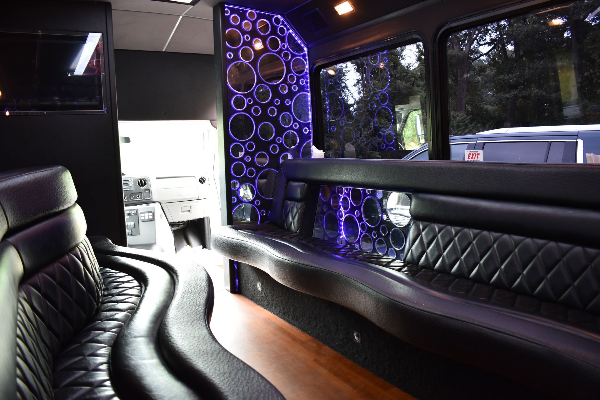 The inside of a limousine with purple lights on the walls.