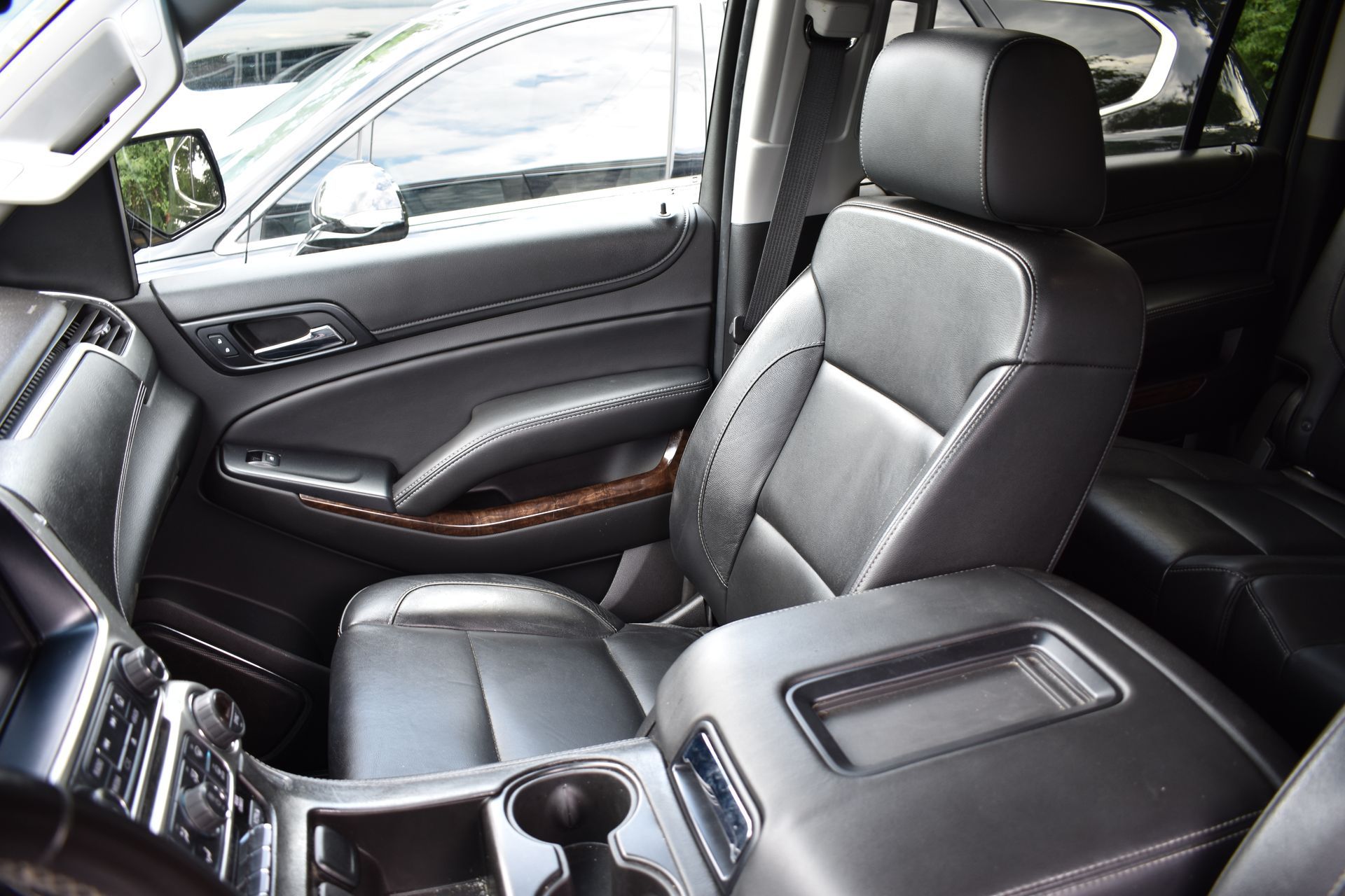 The interior of a chevrolet suburban suv with black leather seats.