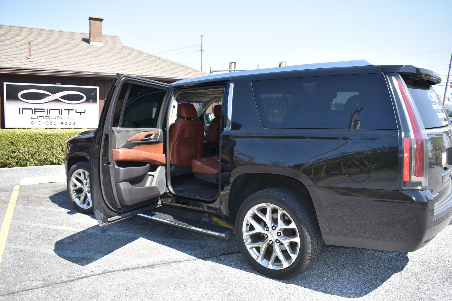 A black suv is parked in a parking lot with its doors open.