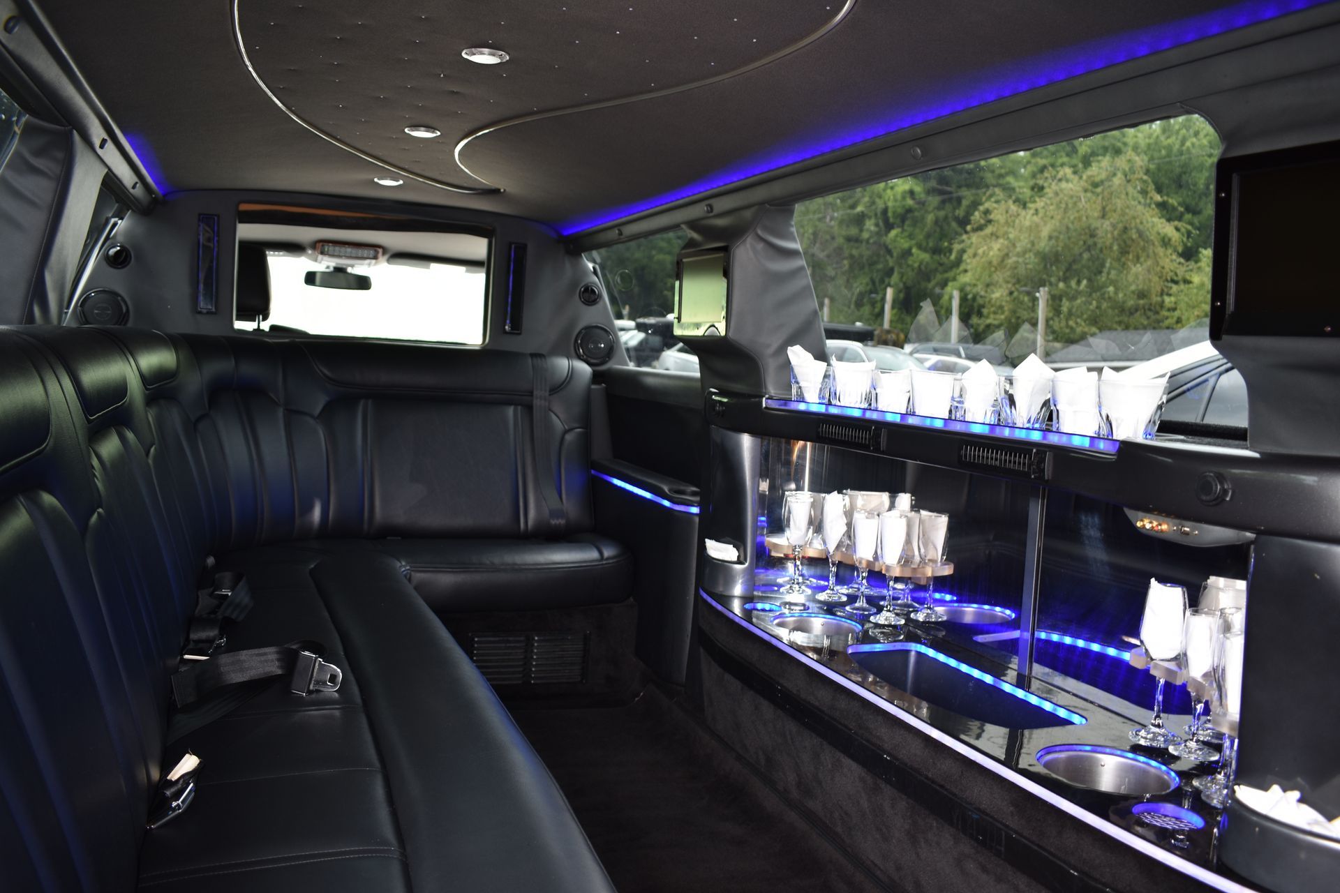 The inside of a limousine with a bar and glasses on it.