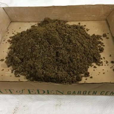 A pile of dirt is sitting in a cardboard box.