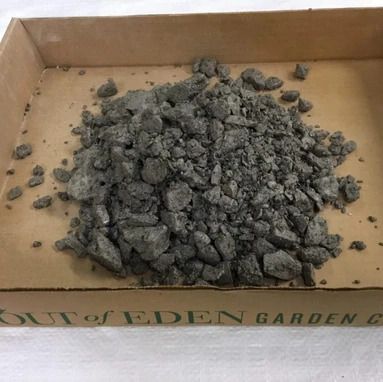 A pile of rocks in a cardboard box that says cat of eden garden