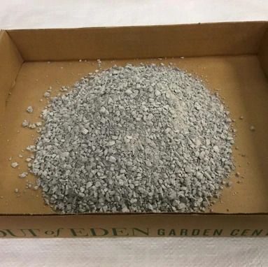 A pile of gravel is in a cardboard box.