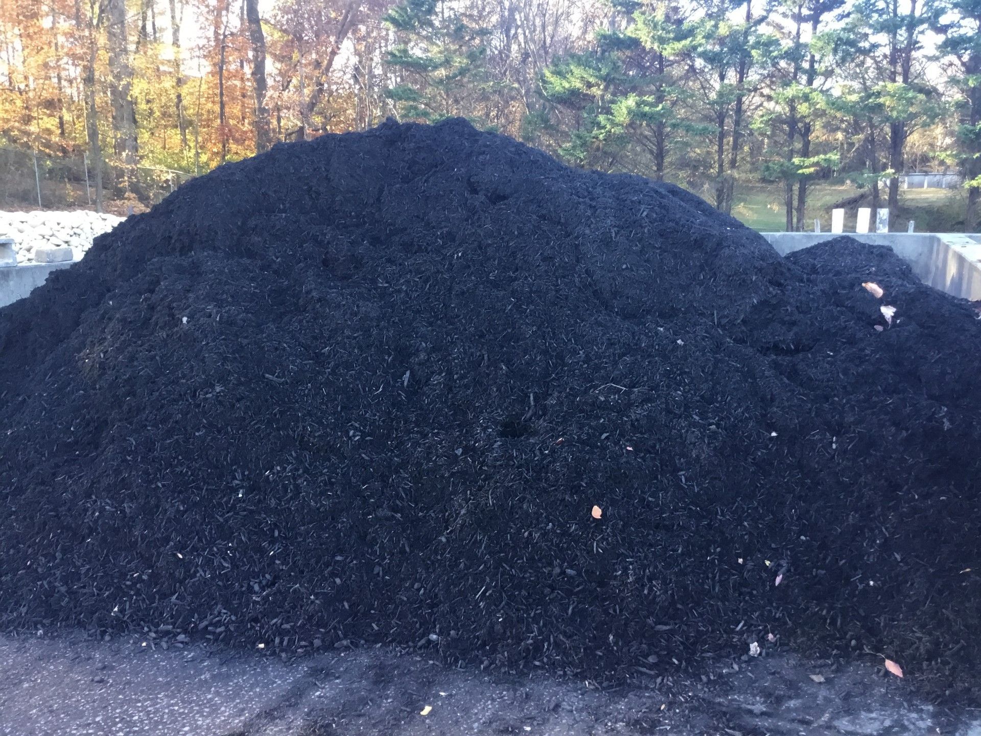 A large pile of black gravel is sitting on the ground