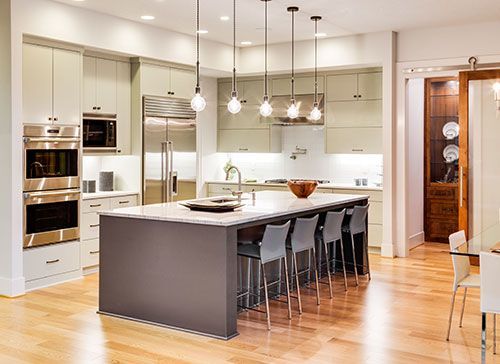 A kitchen with a large island and stainless steel appliances.