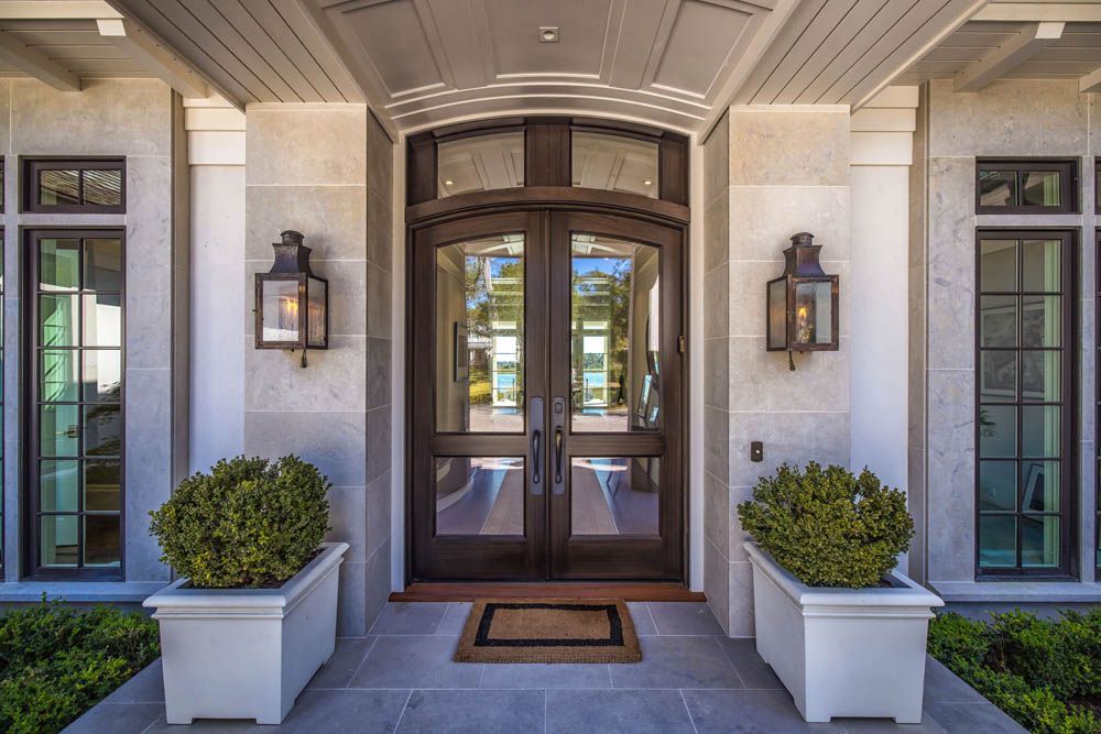 The front door of a house with two planters in front of it.