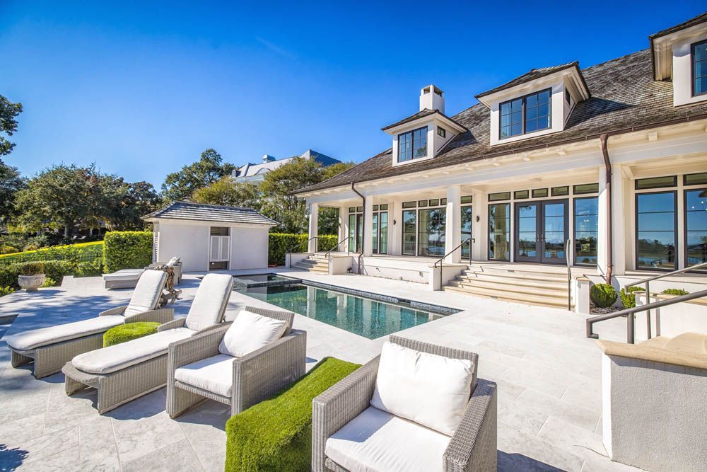 A large white house with a large swimming pool in front of it.