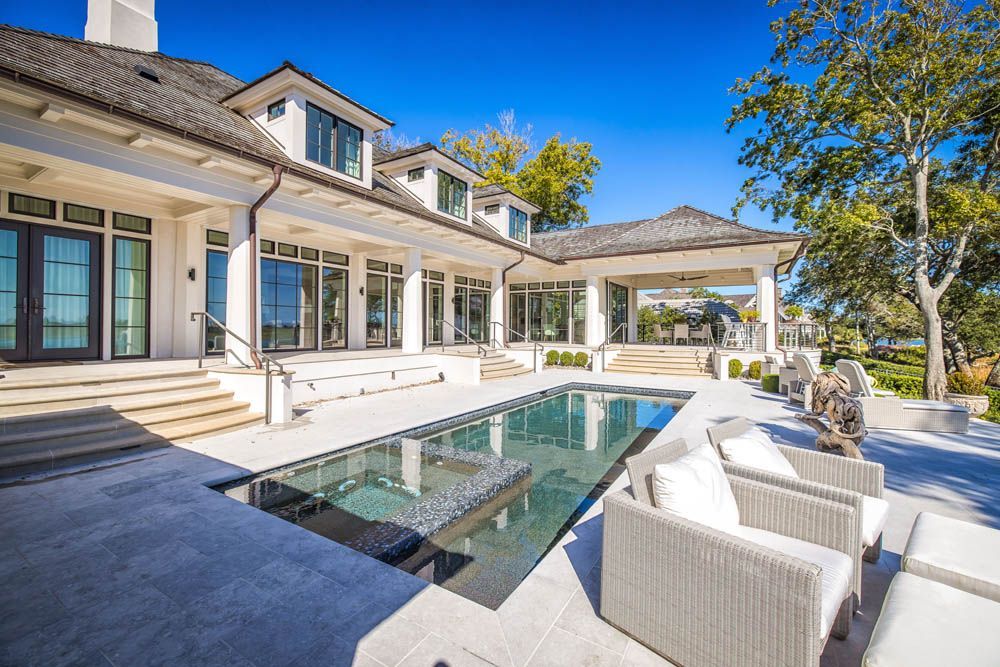 A large white house with a large swimming pool in front of it.