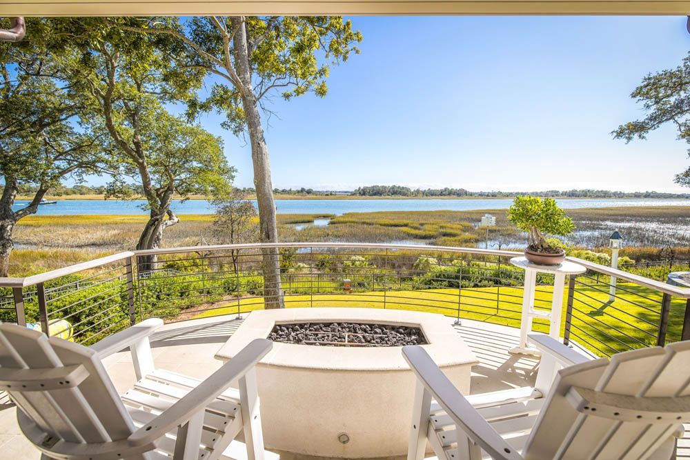 There is a fire pit on the deck with a view of the water.