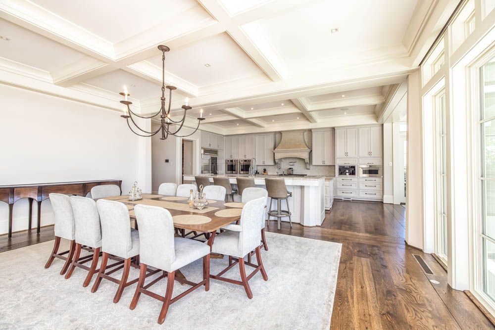 A large dining room with a table and chairs and a kitchen.