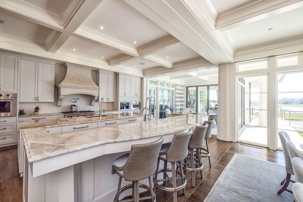 A large kitchen with a large island and lots of windows.