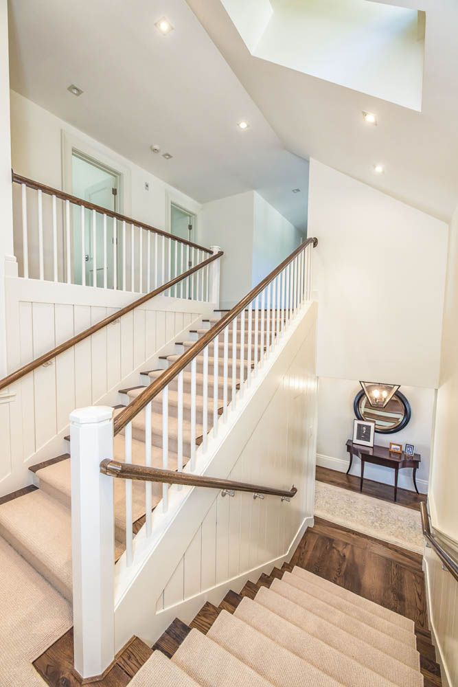 A staircase with a wooden railing and carpeted steps in a house
