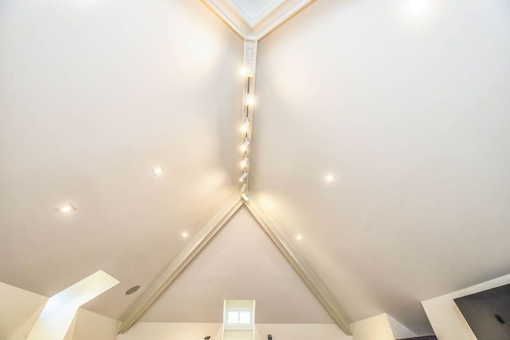 The ceiling of a room with a vaulted ceiling and a window.