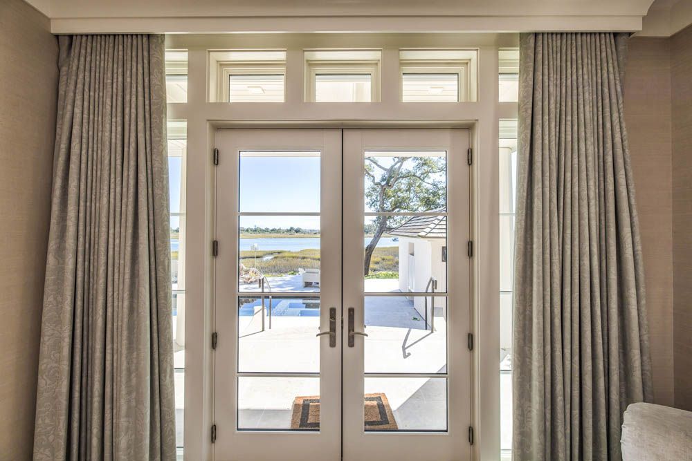 A bedroom with a sliding glass door leading to a balcony.
