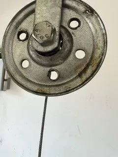 Close-up of a metal wheel hub with bolt holes and a central axle on a white background