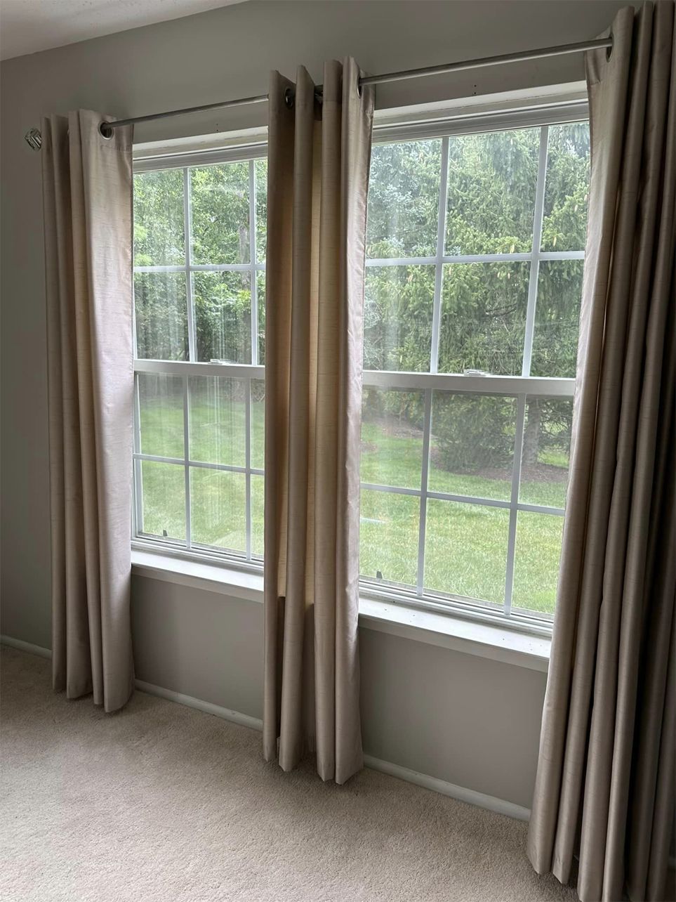 There are two windows in the room with curtains on them.