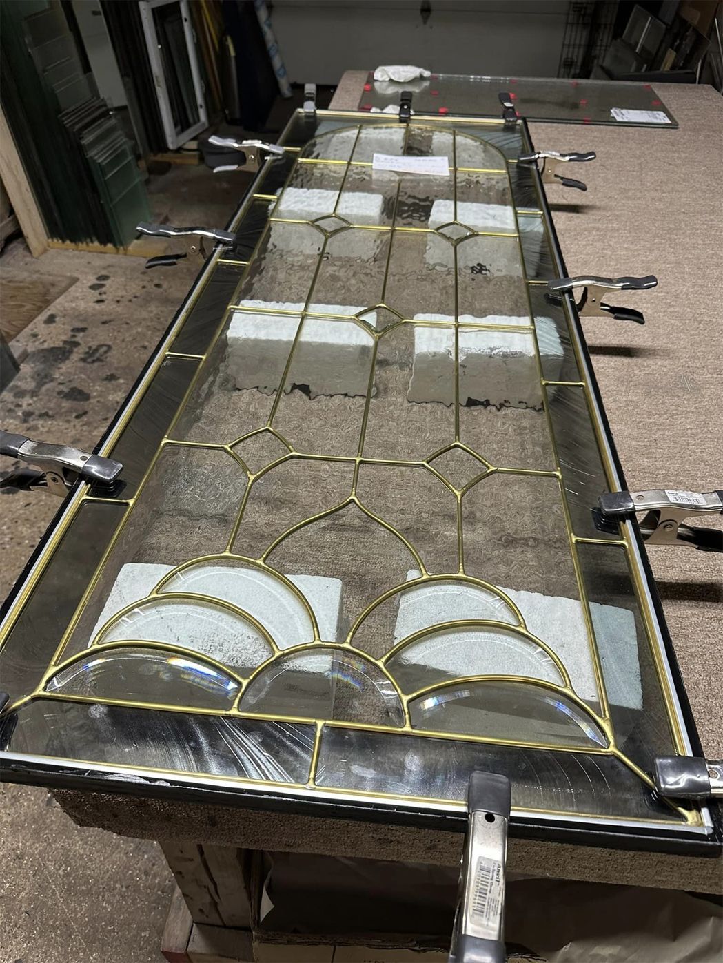 A stained glass window is sitting on top of a wooden table.