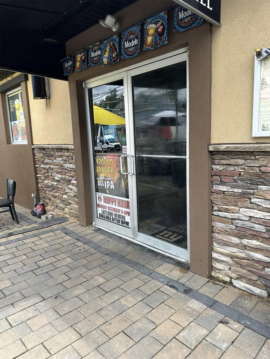 A restaurant with a brick wall and a sliding glass door.