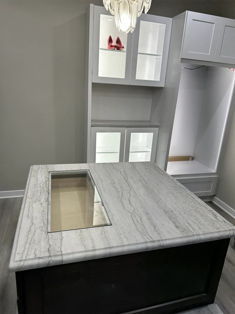 A room with a table , cabinets , and a chandelier.