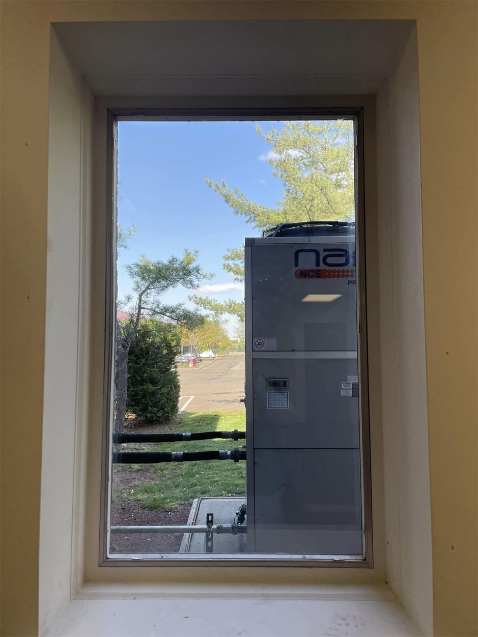 A window with a view of a machine in a room.