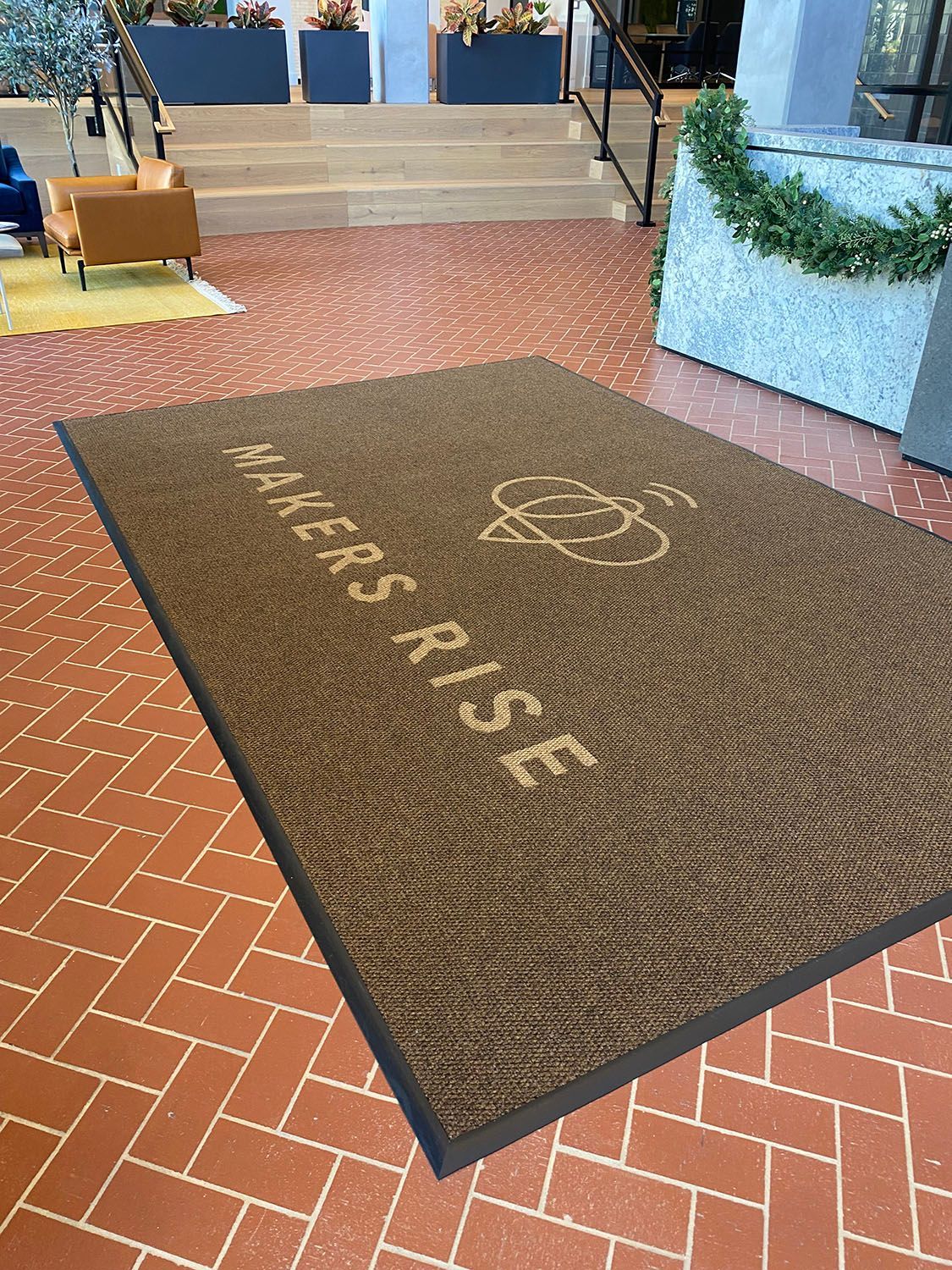 a brown rug is sitting on a brick floor in a lobby