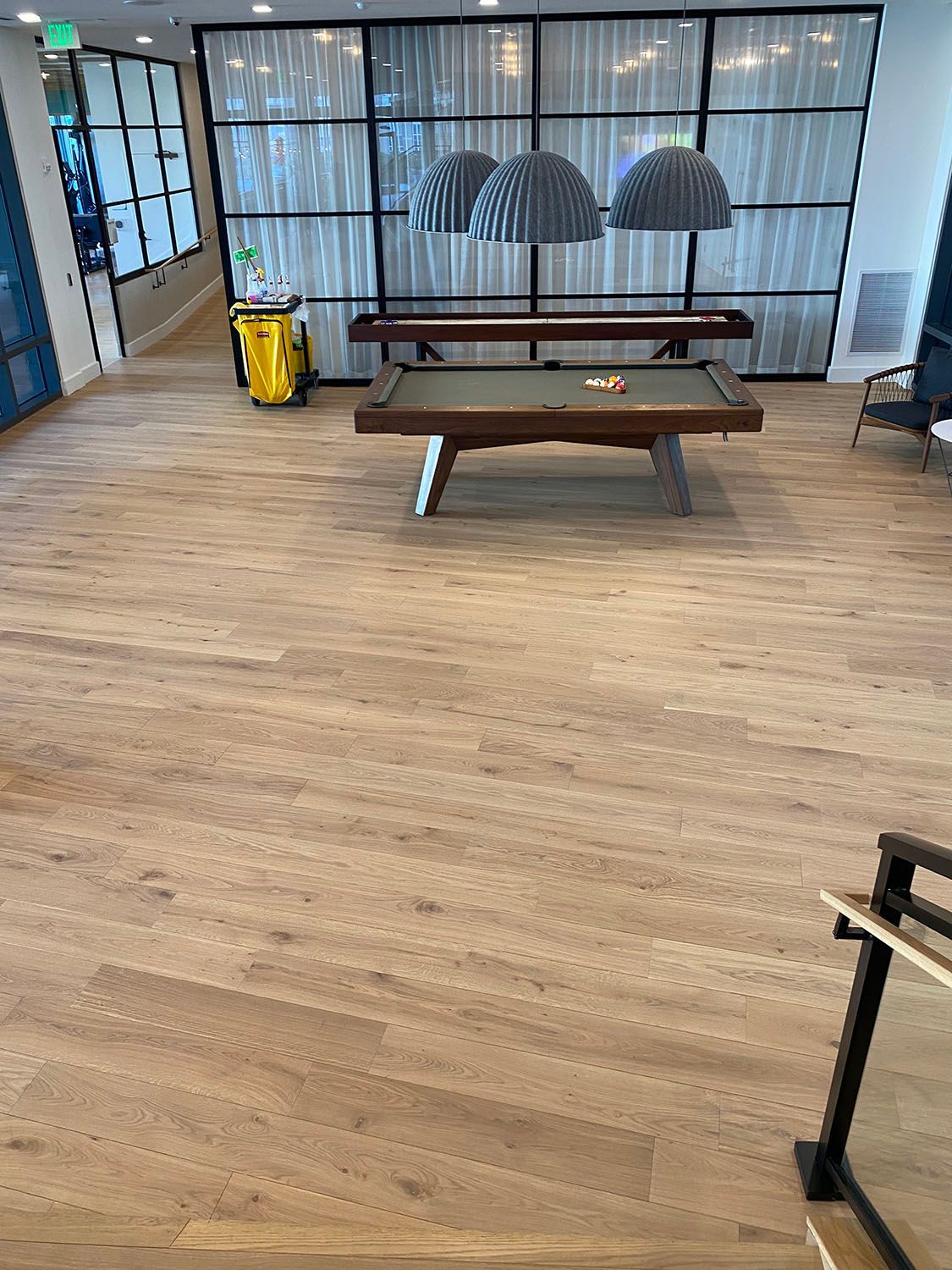 a pool table in the middle of the room with wooden floors