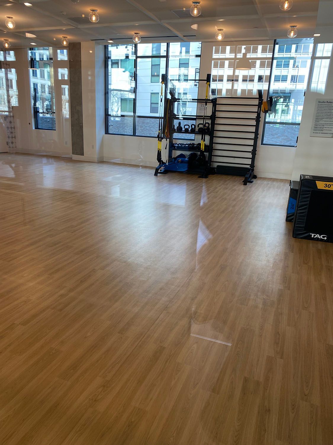 a gym with a wooden floor and glass windows
