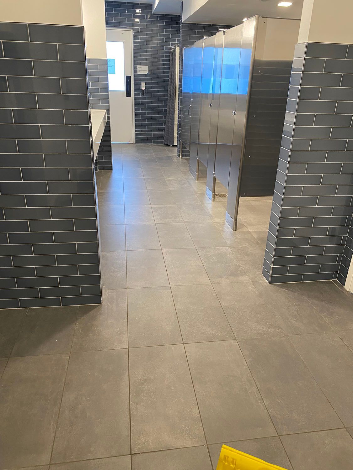 a commercial restroom with brick walls and tile floors
