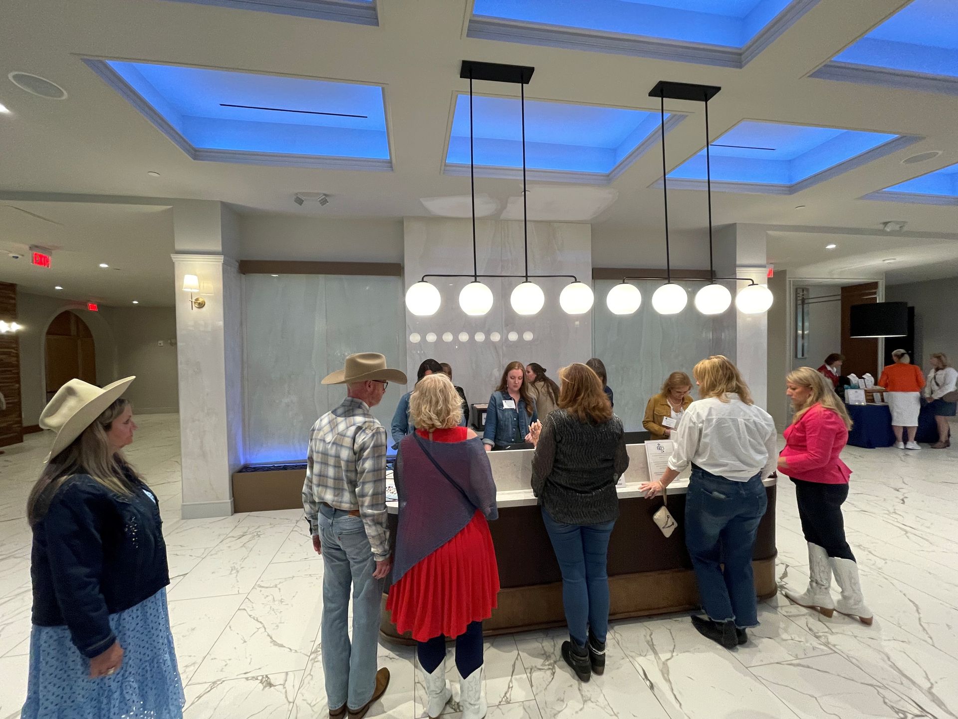 A group of people are standing around a counter in a lobby
