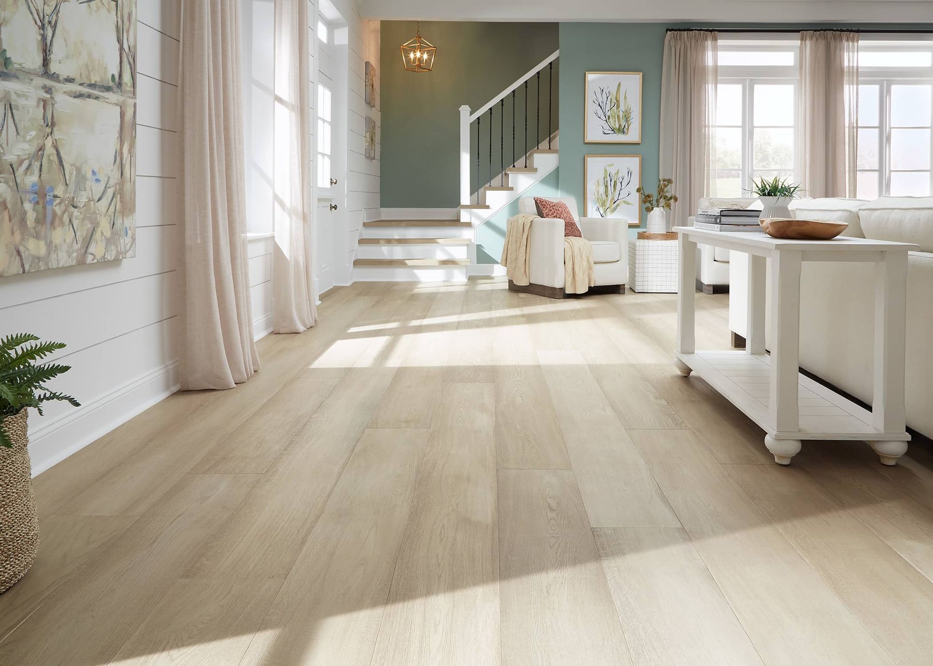 a living room with hardwood floors and white furniture .