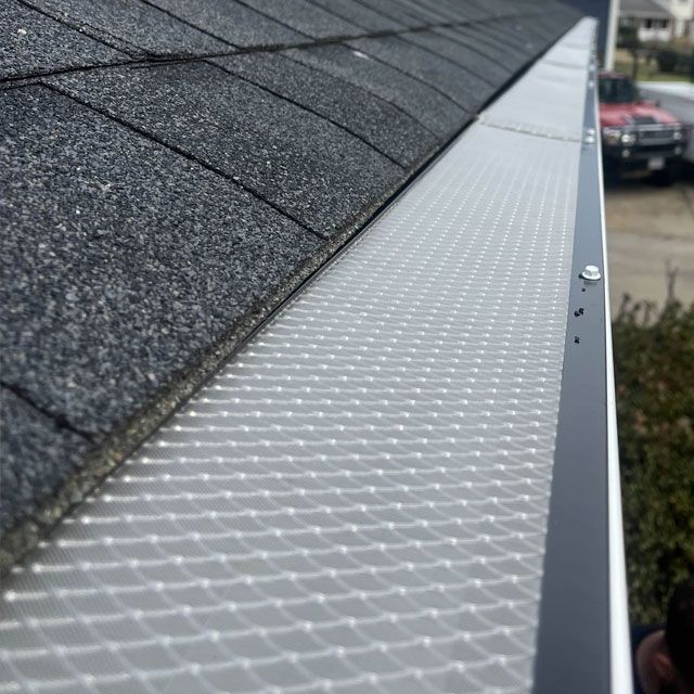 A close up of a gutter on the side of a roof.